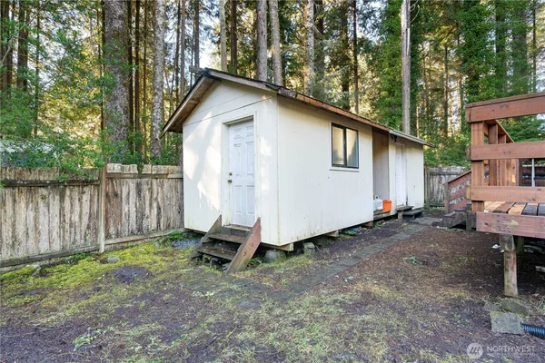 a view of backyard with wooden fence and a large tree