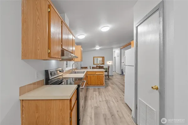 a kitchen with a sink a counter top space stainless steel appliances and cabinets