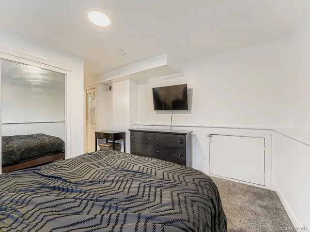 a bedroom with a bed and a flat tv screen