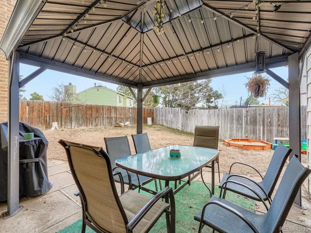 a backyard of a house with table and chairs