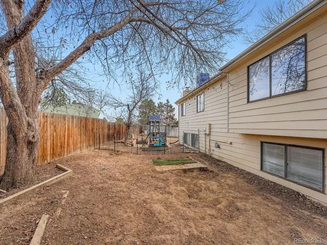 a view of a house with a yard and large trees