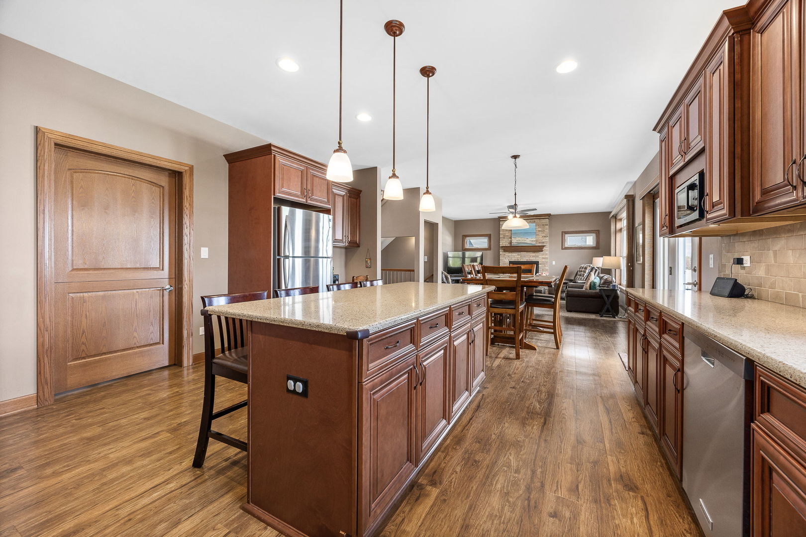311 West Frontier Drive Minooka, IL 60447 - Photo 11 of 44 a kitchen with stainless steel appliances granite countertop a table chairs wooden floors and a large window