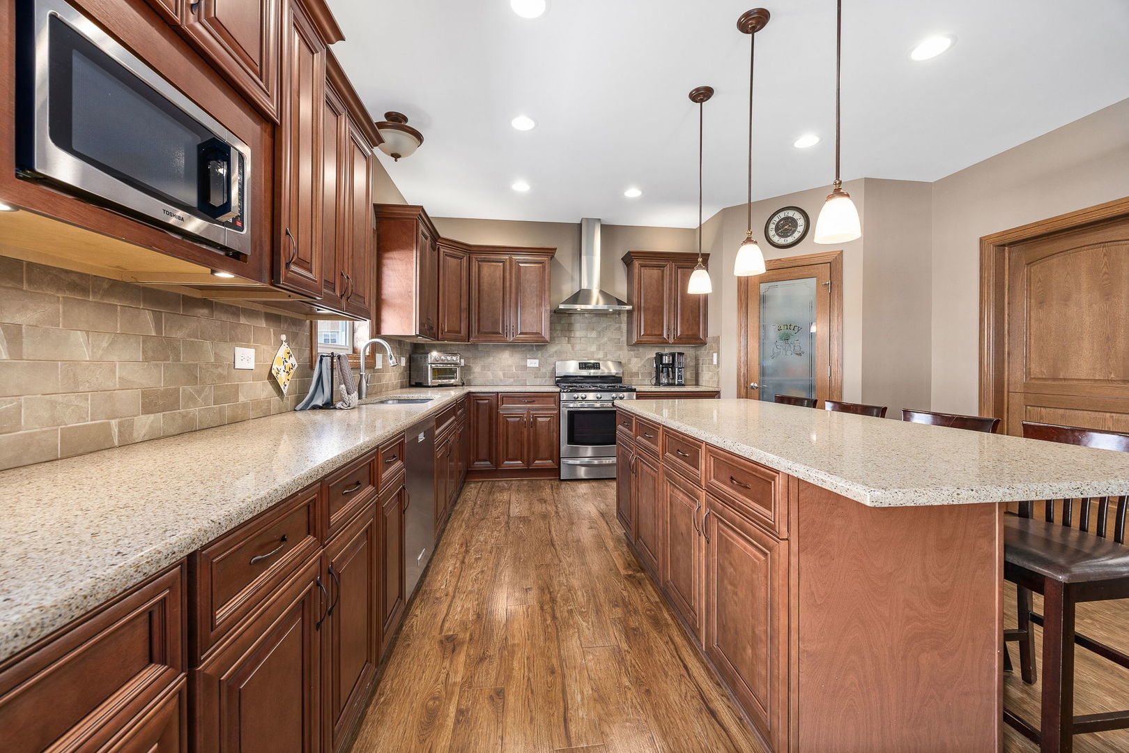 311 West Frontier Drive Minooka, IL 60447 - Photo 12 of 44 a kitchen with stainless steel appliances granite countertop a sink a stove and a wooden floors