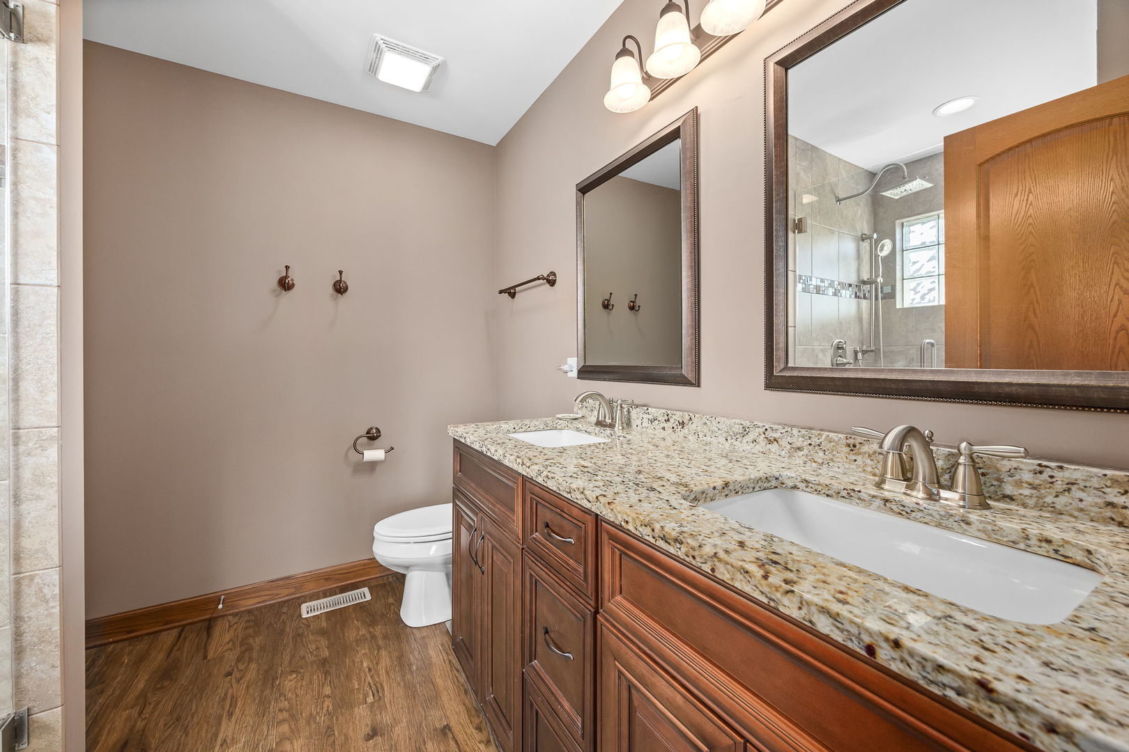 311 West Frontier Drive Minooka, IL 60447 - Photo 21 of 44 a bathroom with a granite countertop sink a toilet and a large mirror