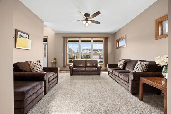 a kitchen with stainless steel appliances granite countertop a stove a sink dishwasher a refrigerator and a dining table with wooden floor