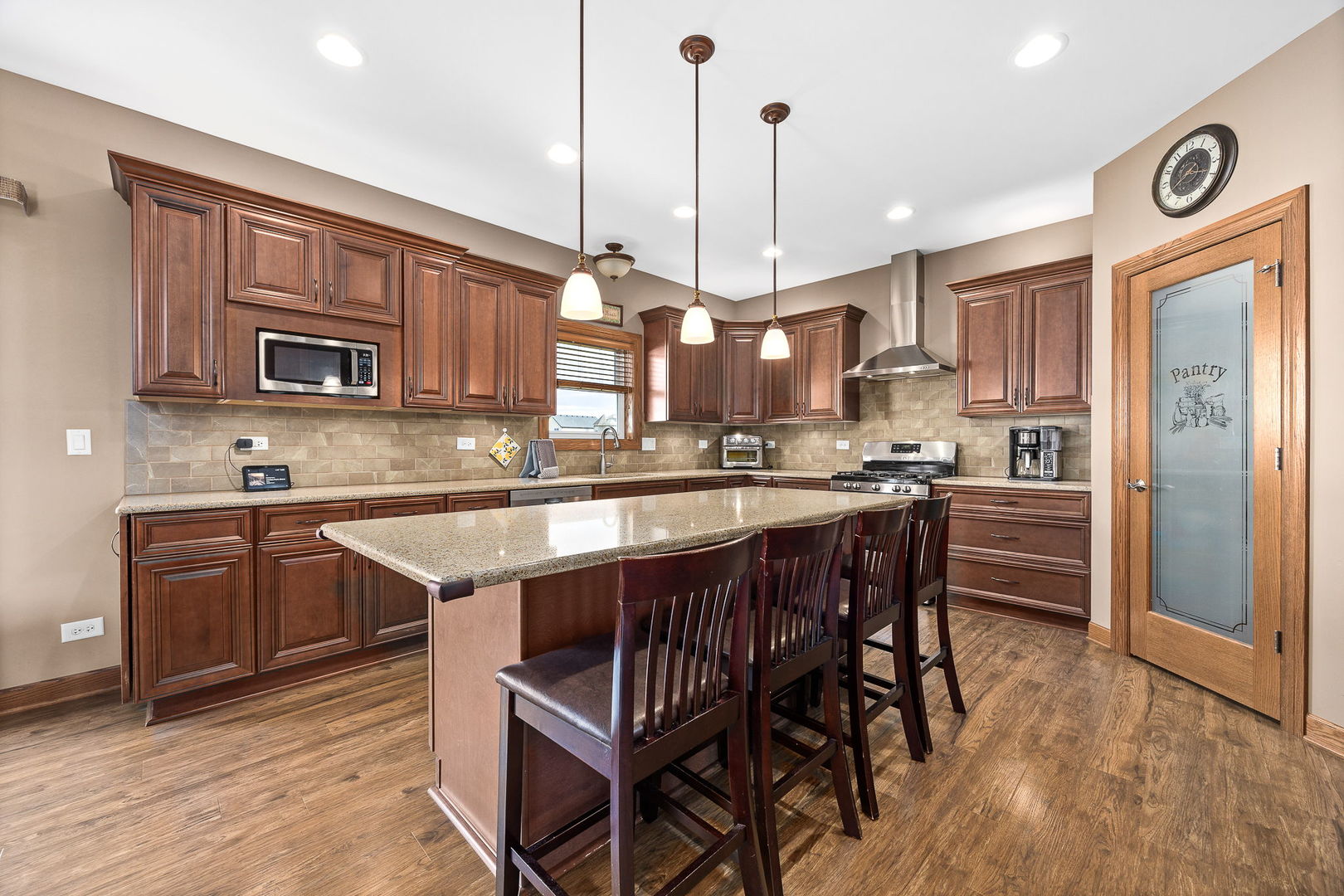 311 West Frontier Drive Minooka, IL 60447 - Photo 9 of 44 a kitchen with stainless steel appliances granite countertop a stove a sink dishwasher a refrigerator and a dining table with wooden floor