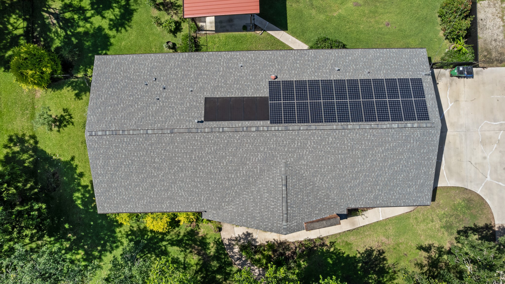 616 Cannan Drive Angleton, TX 77515 - Photo 42 of 49 Aerial perspective highlights the home's expansive roofline, complemented by installed solar panels that may help support energy efficiency. The generous lot size and mature surrounding trees create a private setting with ample outdoor space to enjoy.