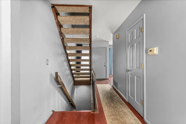a view of a hallway with wooden floor and entryway