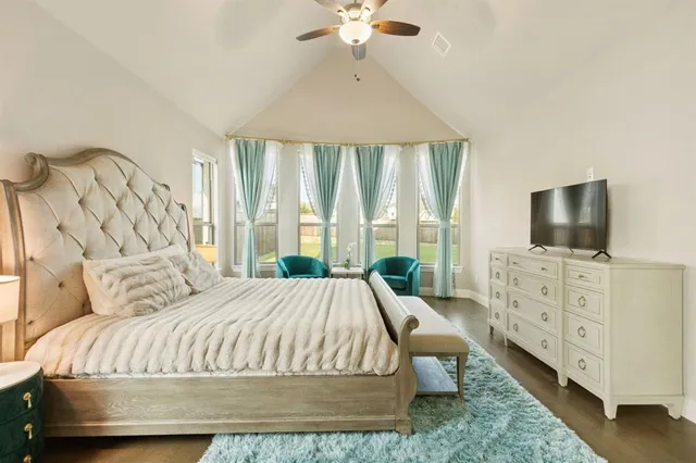 a bedroom with a bed a large window and flat screen tv