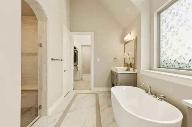 a bathroom with a white tub shower sink and mirror