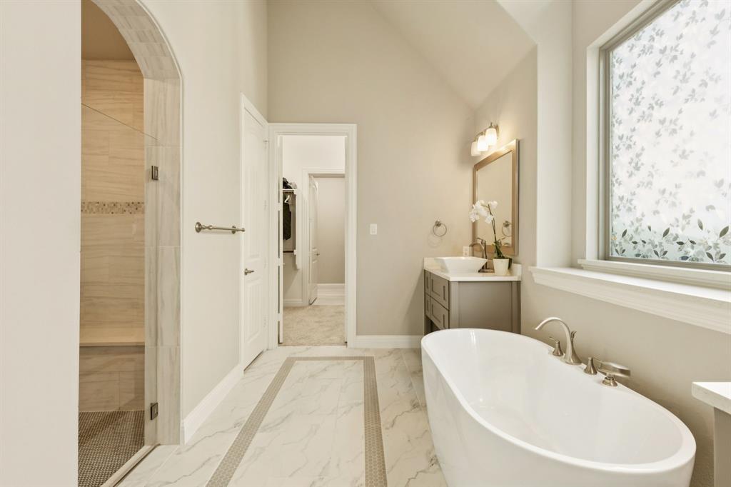 3508 Ruffian Court Celina, TX 75009 - Photo 17 of 38 a bathroom with a white tub shower sink and mirror