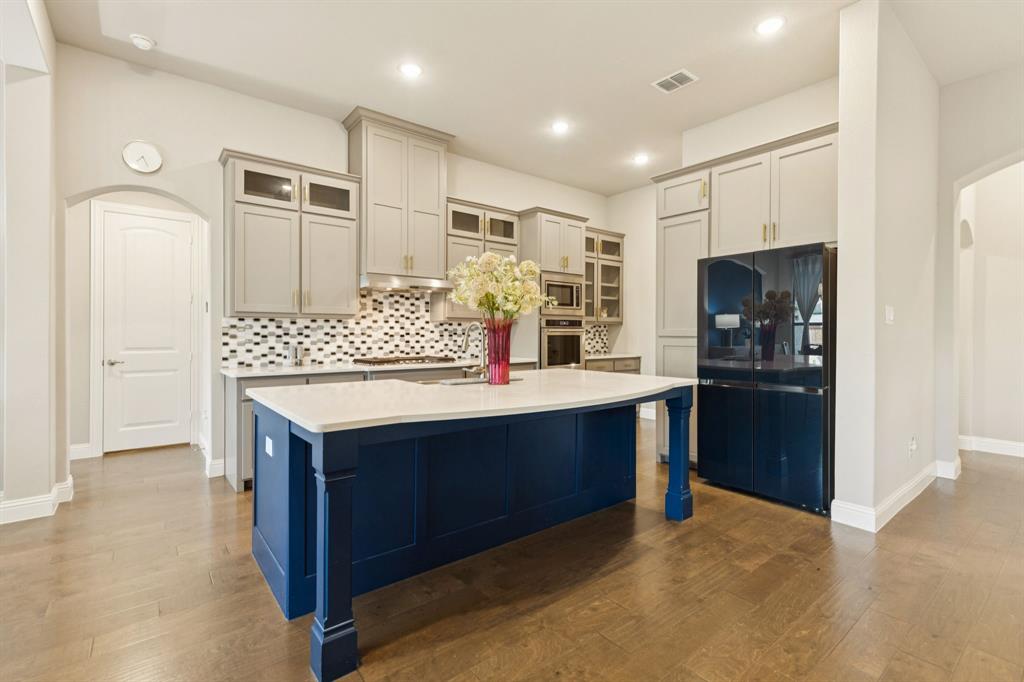3508 Ruffian Court Celina, TX 75009 - Photo 5 of 38 a kitchen with kitchen island stainless steel appliances a sink stove and refrigerator