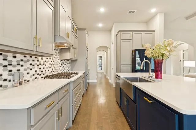 a kitchen with kitchen island granite countertop a sink a counter top space and cabinets