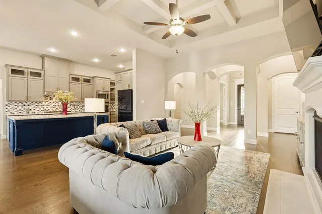 a living room with furniture and a large mirror with wooden floor