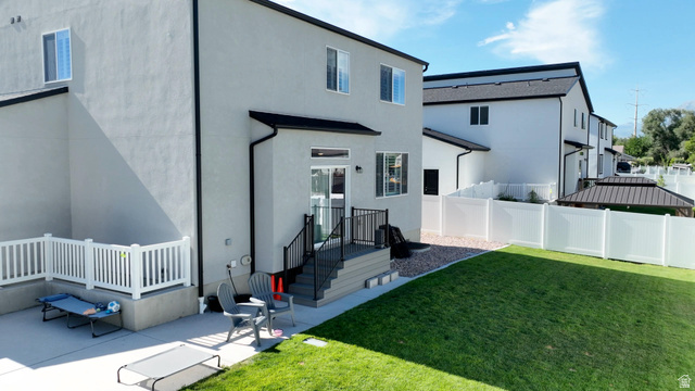 983 South 950 West Provo, UT 84601 - Photo 50 of 56 Rear exterior featuring light gray stucco siding, black roofline, and white vinyl fencing