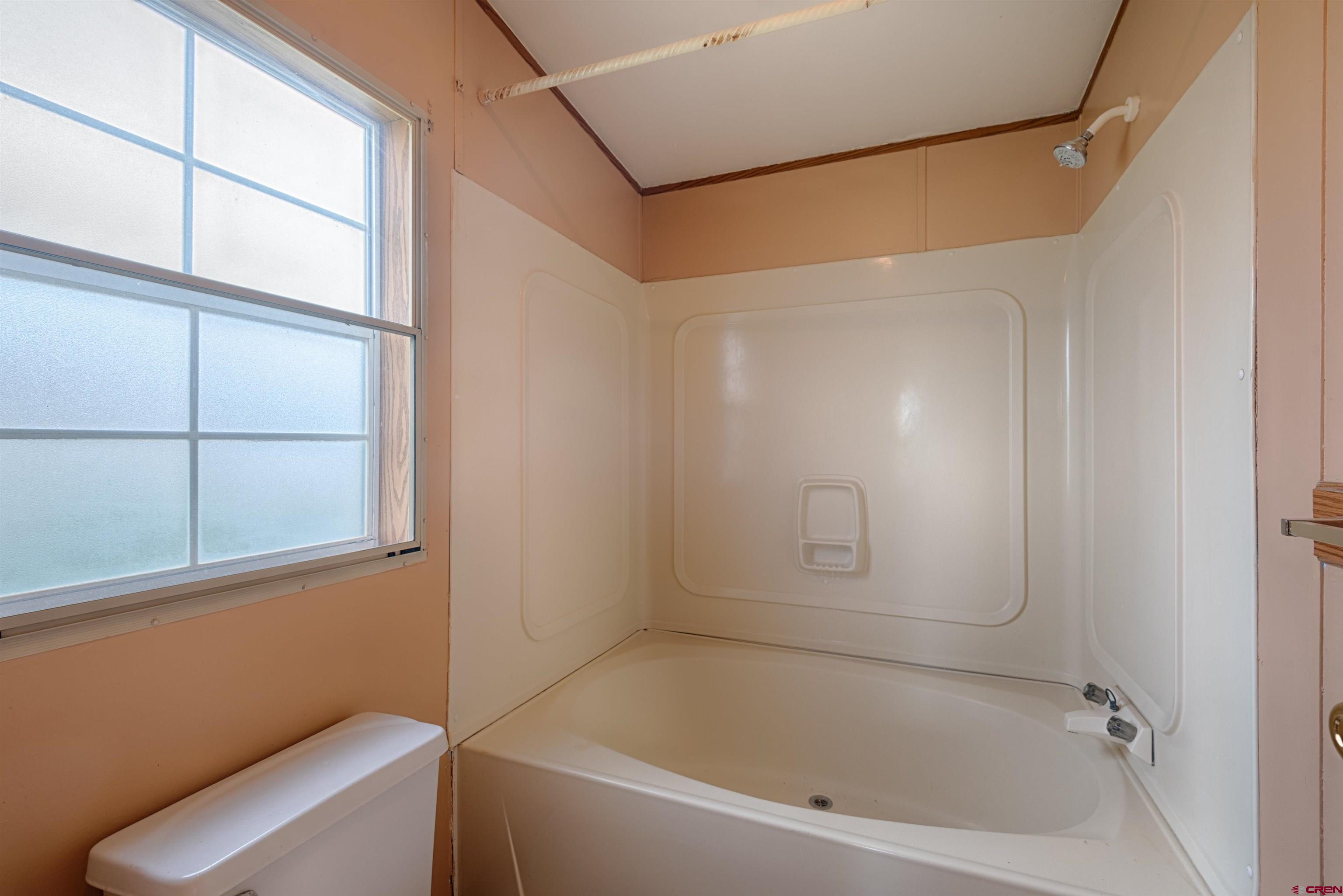 67135 N Road Montrose, CO 81401 - Photo 19 of 35 a bathroom with a bathtub and window