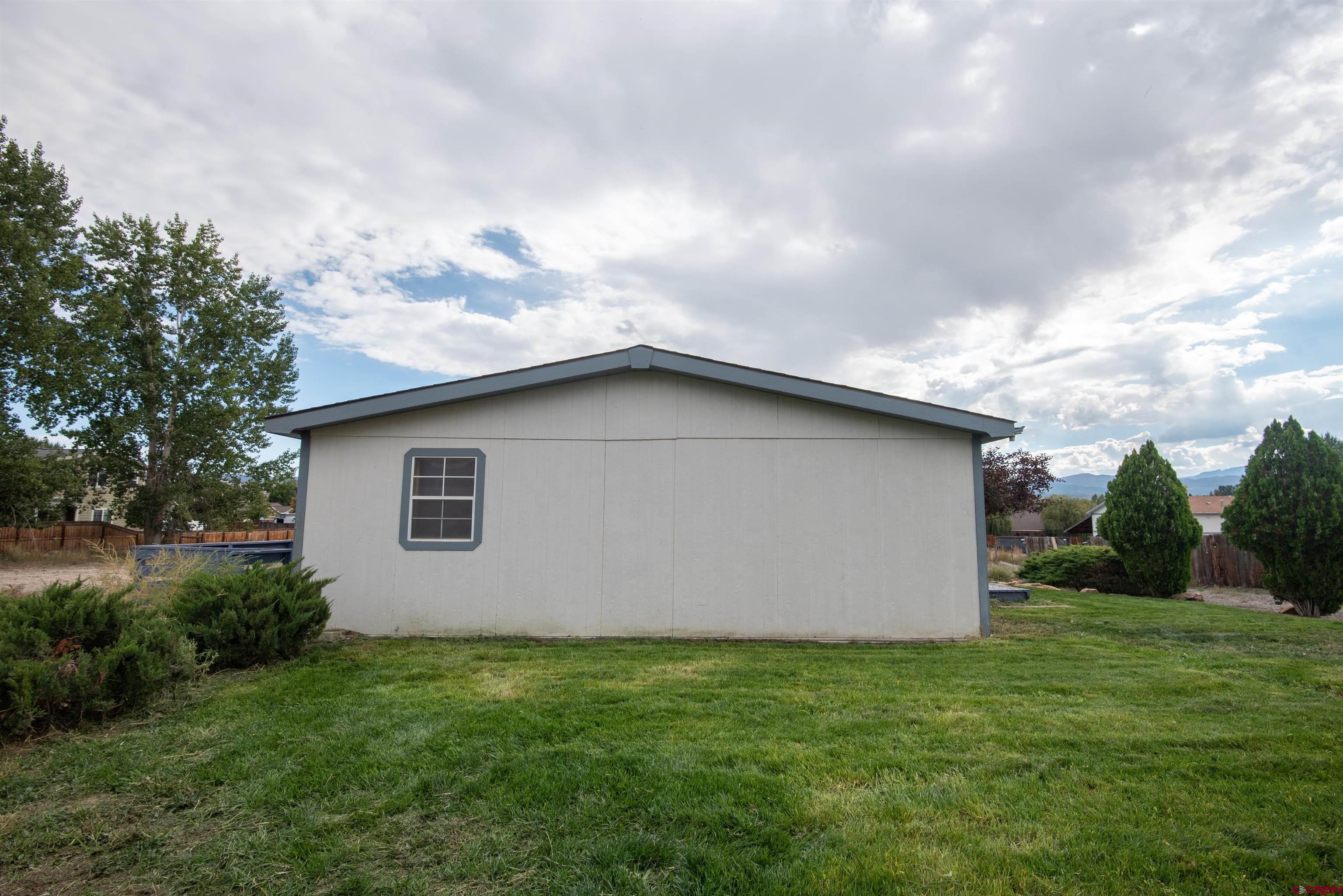 67135 N Road Montrose, CO 81401 - Photo 3 of 35 a backyard of a house with lots of green space