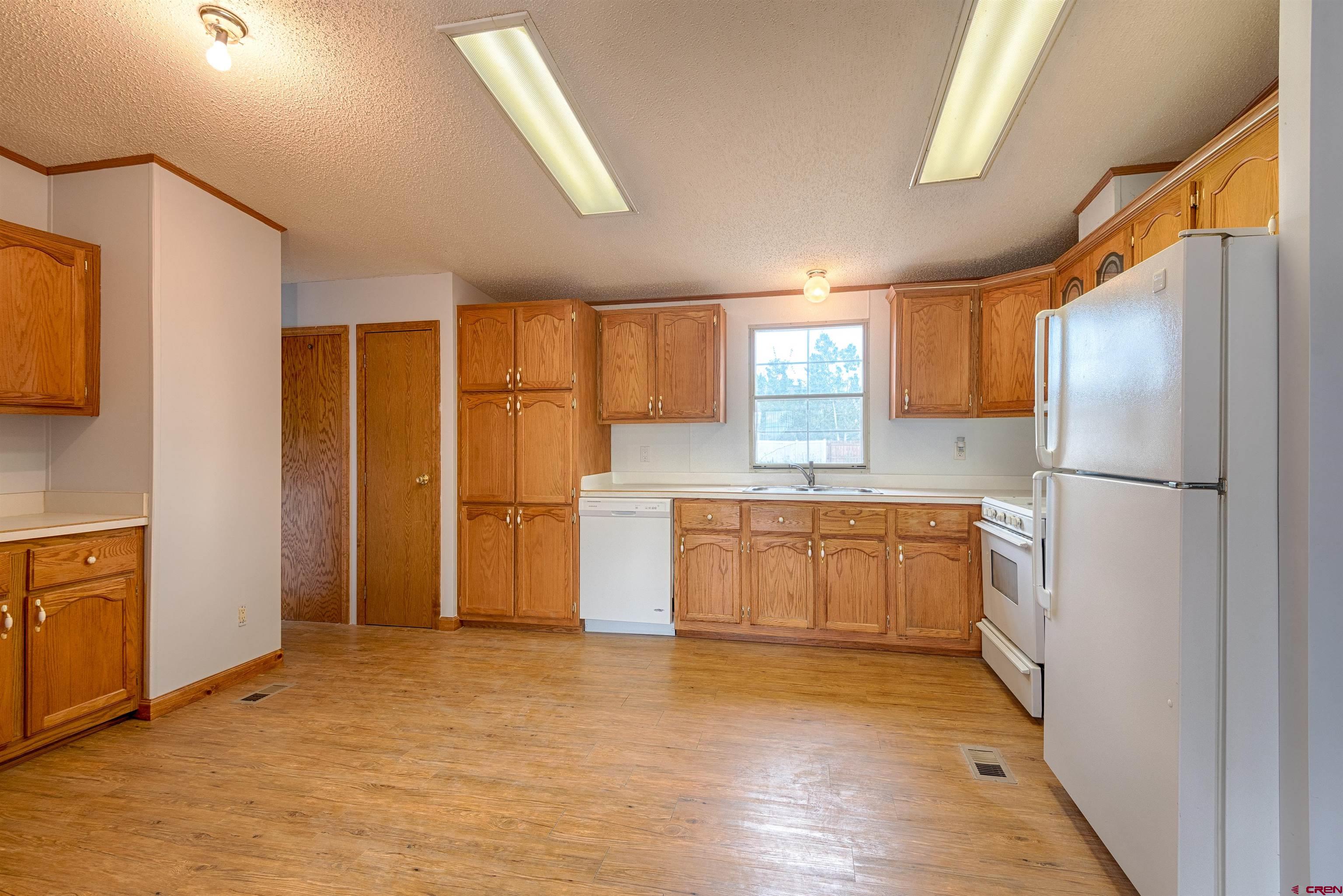 67135 N Road Montrose, CO 81401 - Photo 9 of 35 a kitchen with a refrigerator a sink and cabinets