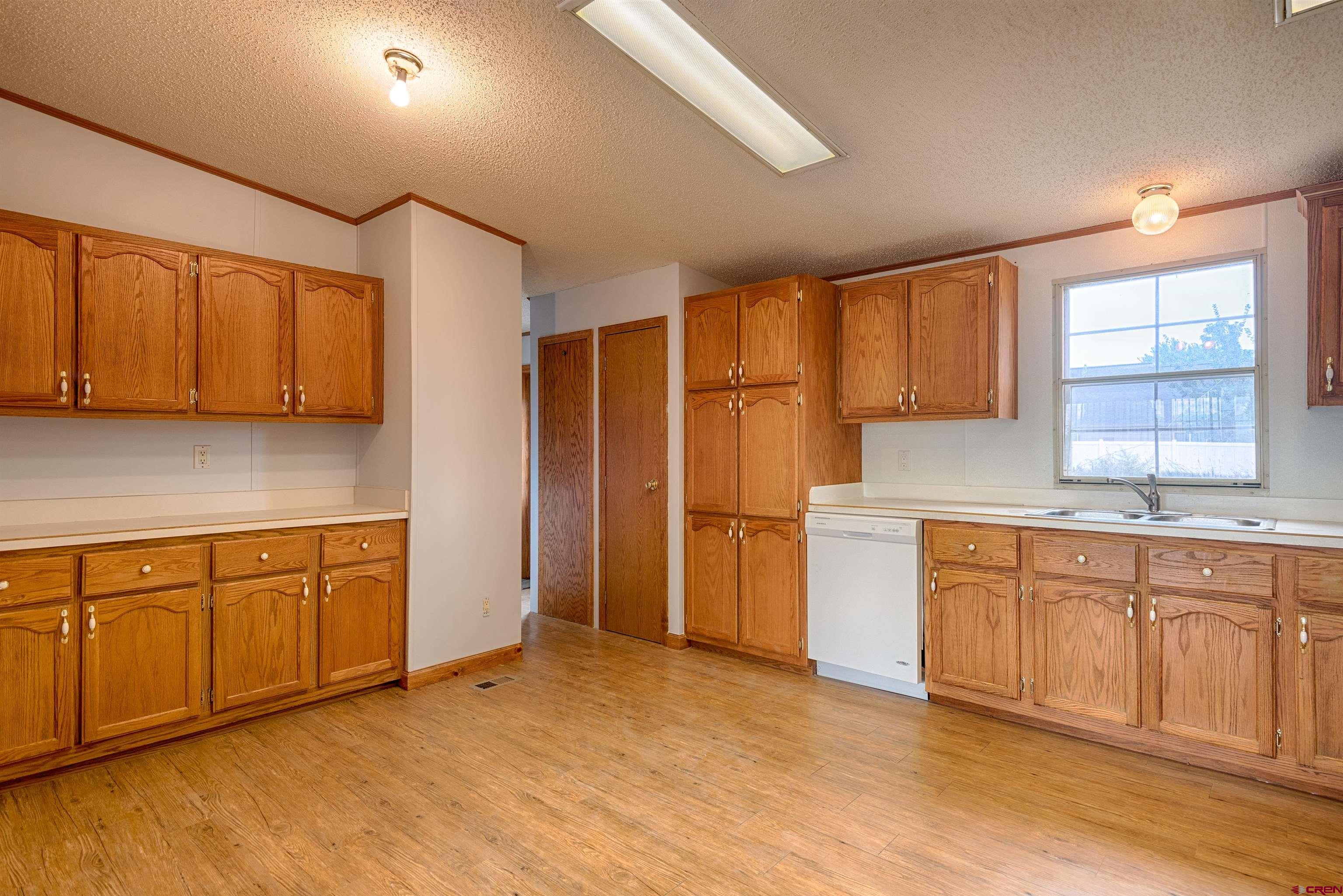 67135 N Road Montrose, CO 81401 - Photo 10 of 35 a kitchen with granite countertop a sink cabinets stainless steel appliances and a window