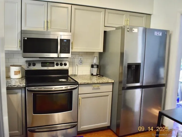 a kitchen with stainless steel appliances granite countertop a refrigerator stove and microwave