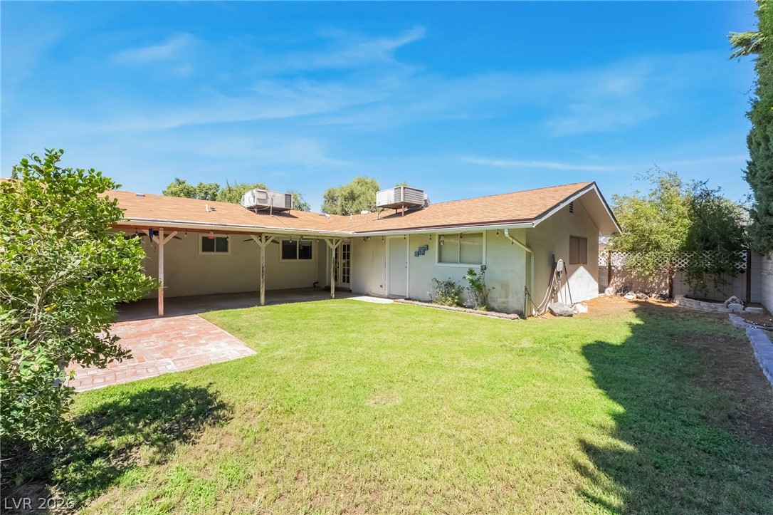 1324 Appaloosa Road Boulder City, NV 89005 - Photo 34 of 38 A spacious green lawn sits beside a covered patio and low-maintenance shingle roof.