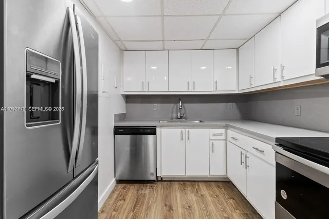 a kitchen with stainless steel appliances white cabinets and a refrigerator