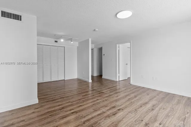 a view of an empty room with wooden floor