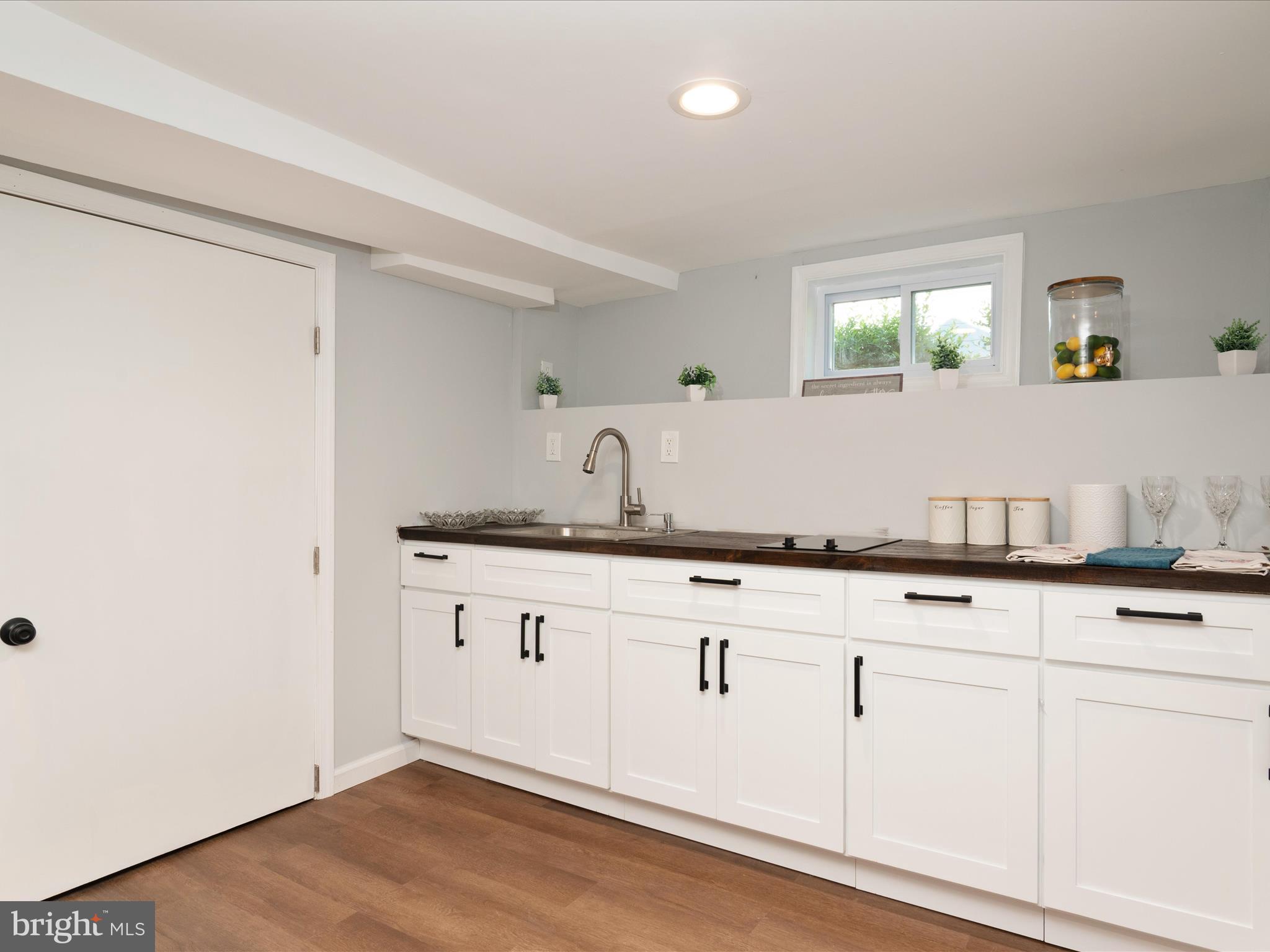 1119 Overbrook Road Baltimore, MD 21239 - Photo 26 of 72 a sink with white cabinets and wooden floor