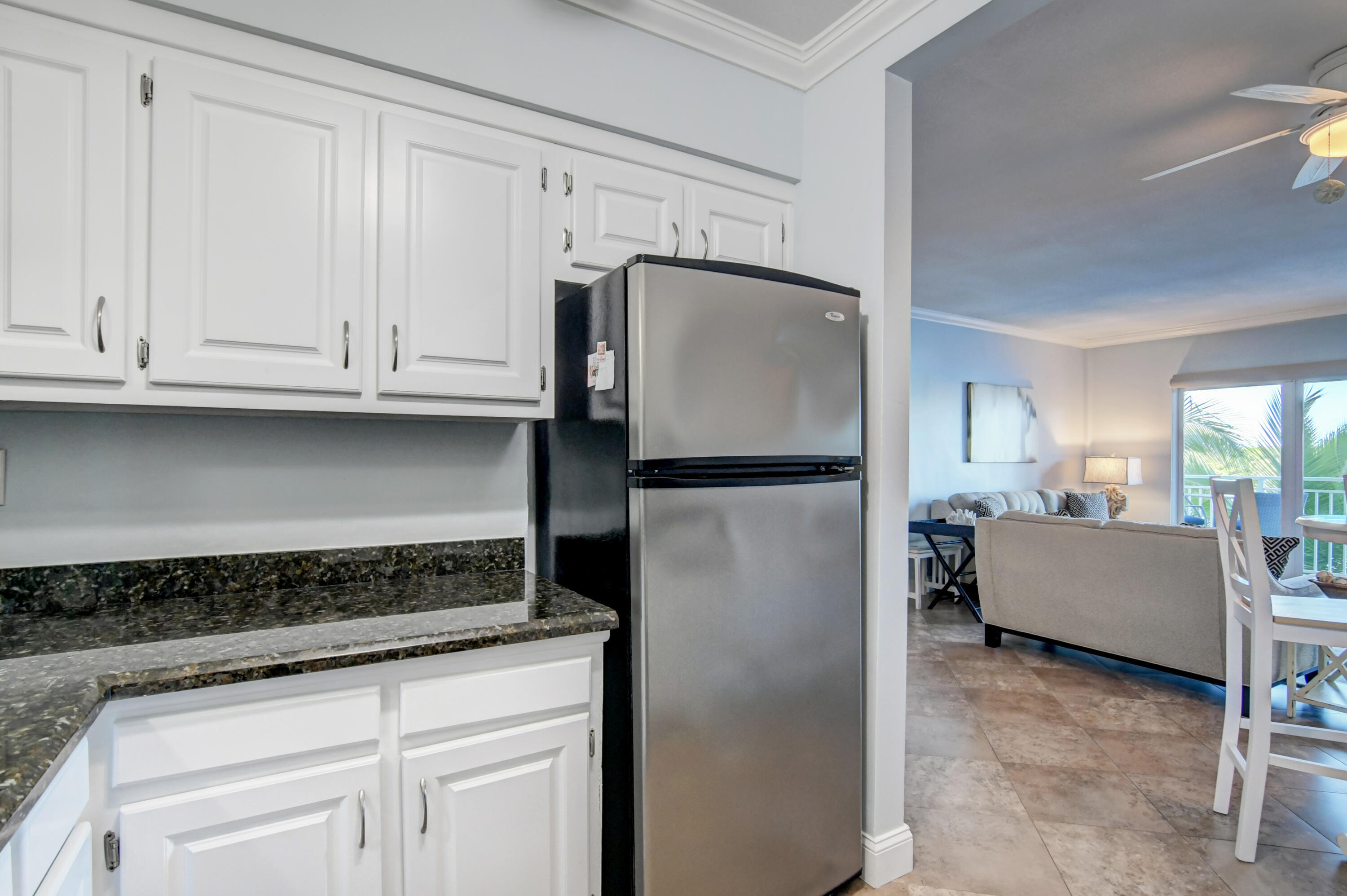 6520 North Ocean Boulevard, Unit 240 Ocean Ridge, FL 33435 - Photo 12 of 29 a kitchen with granite countertop a refrigerator and cabinets