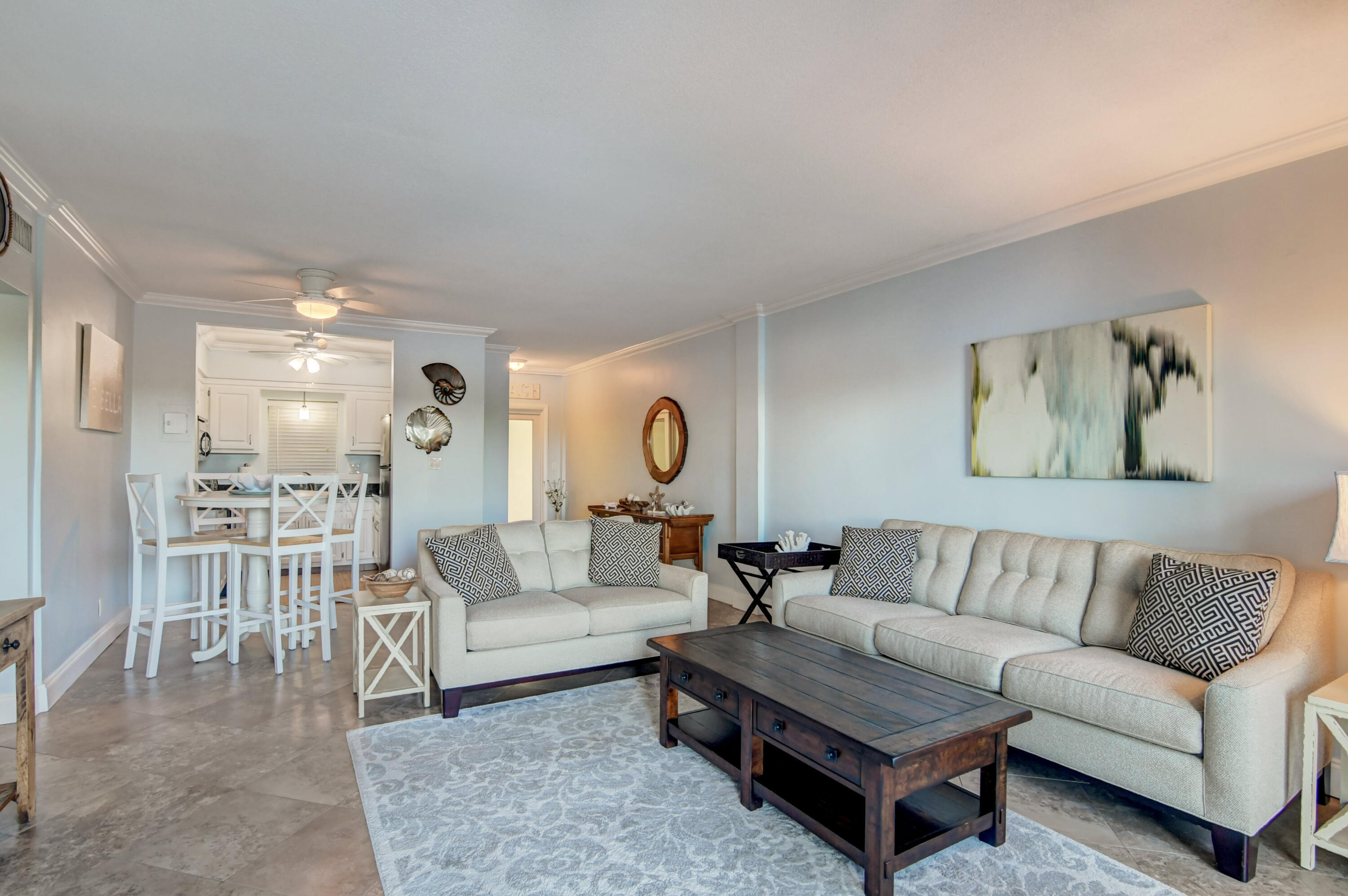 6520 North Ocean Boulevard, Unit 240 Ocean Ridge, FL 33435 - Photo 8 of 29 a living room with furniture a rug and a chandelier