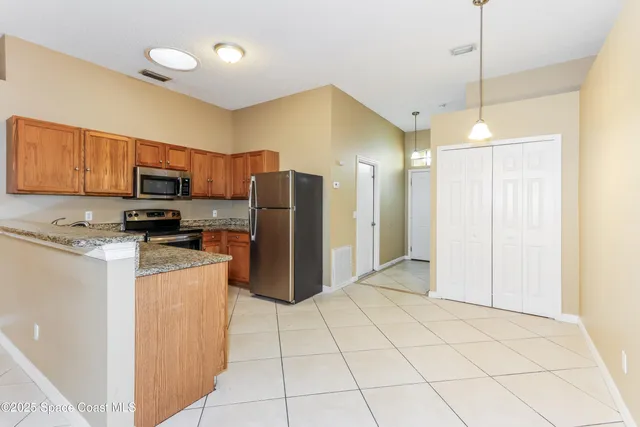 a kitchen with stainless steel appliances granite countertop a refrigerator a stove top oven a sink and dishwasher