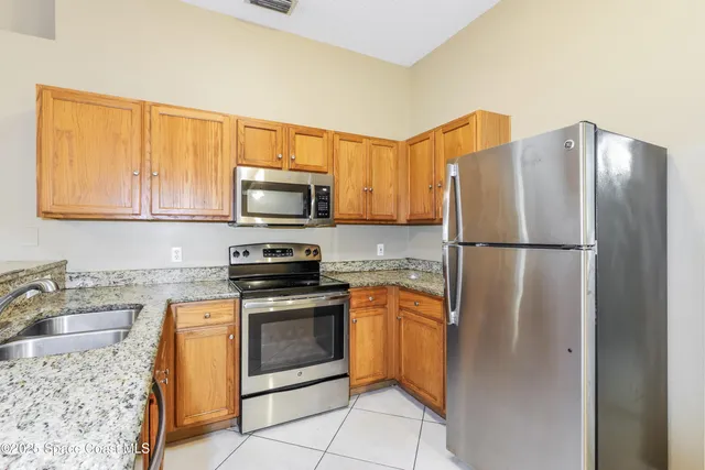 a kitchen with stainless steel appliances granite countertop a refrigerator and a sink