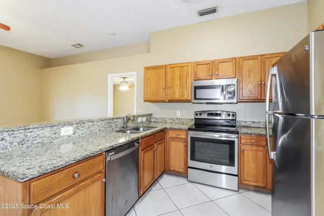 a kitchen with stainless steel appliances granite countertop a stove a sink and a refrigerator