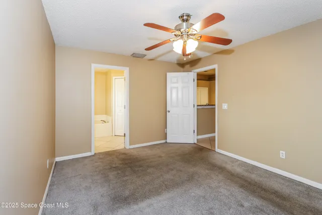 an empty room and a chandelier fan