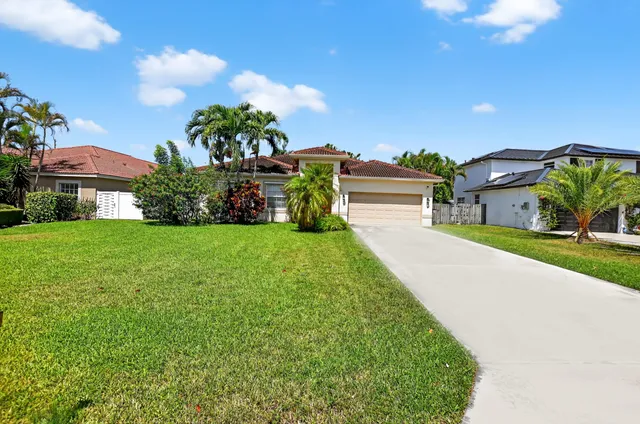 a view of a house with a big yard and potted plants