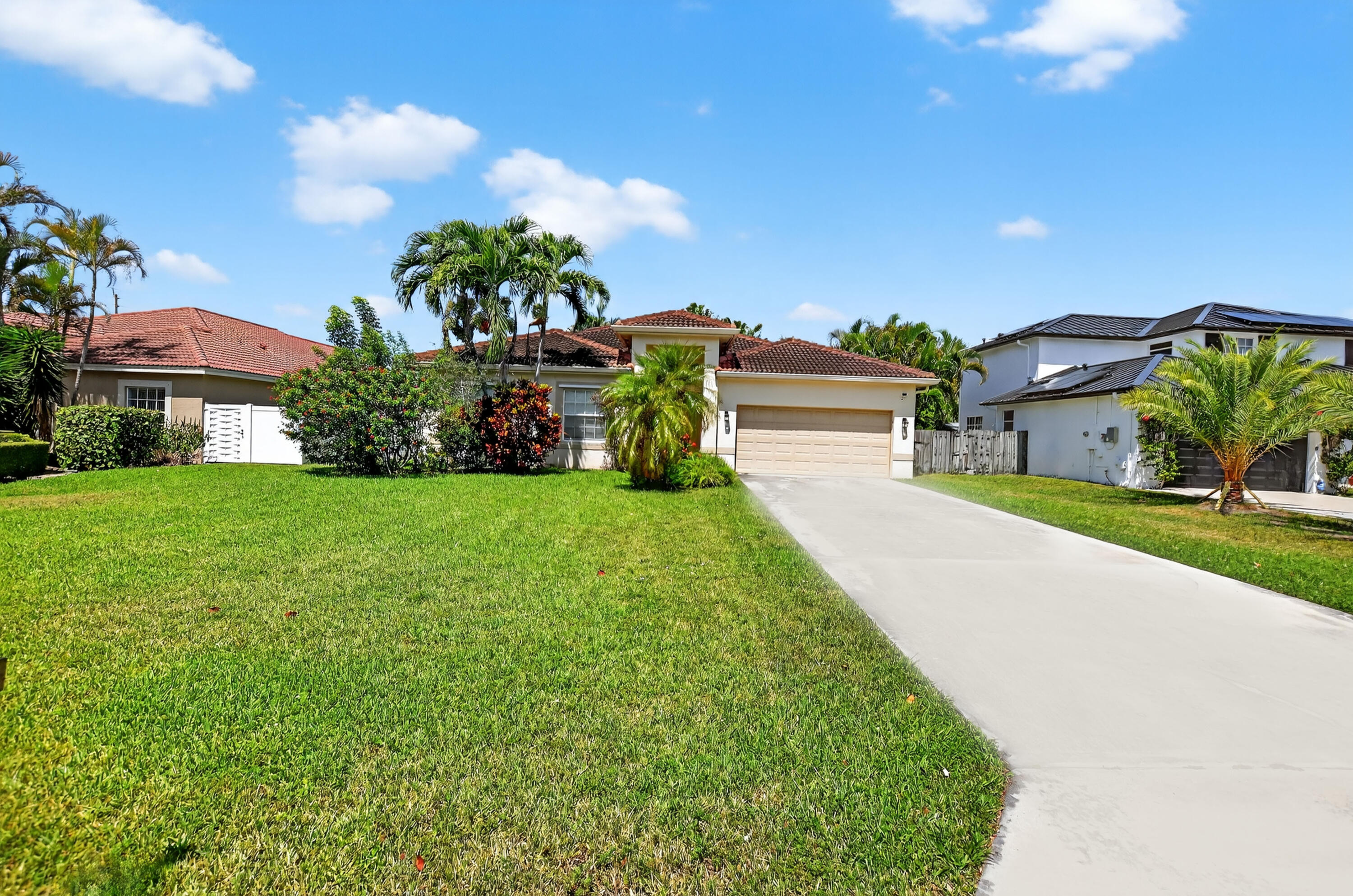 a view of a house with a big yard and potted plants