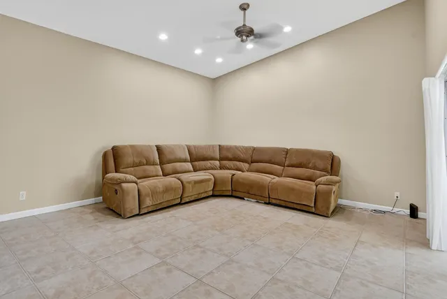 a living room with a couch and a ceiling fan