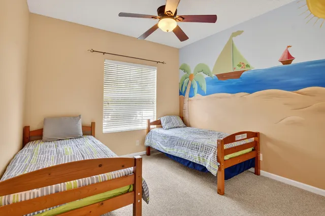 a bedroom with a bed and a chandelier fan