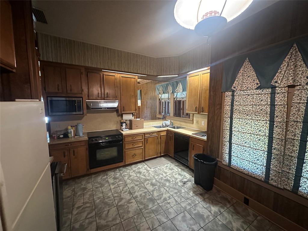 2276 Main Street Haynesville, LA 71038 - Photo 7 of 22 a kitchen with stainless steel appliances granite countertop a refrigerator a sink dishwasher a stove and a dining table with wooden cabinet