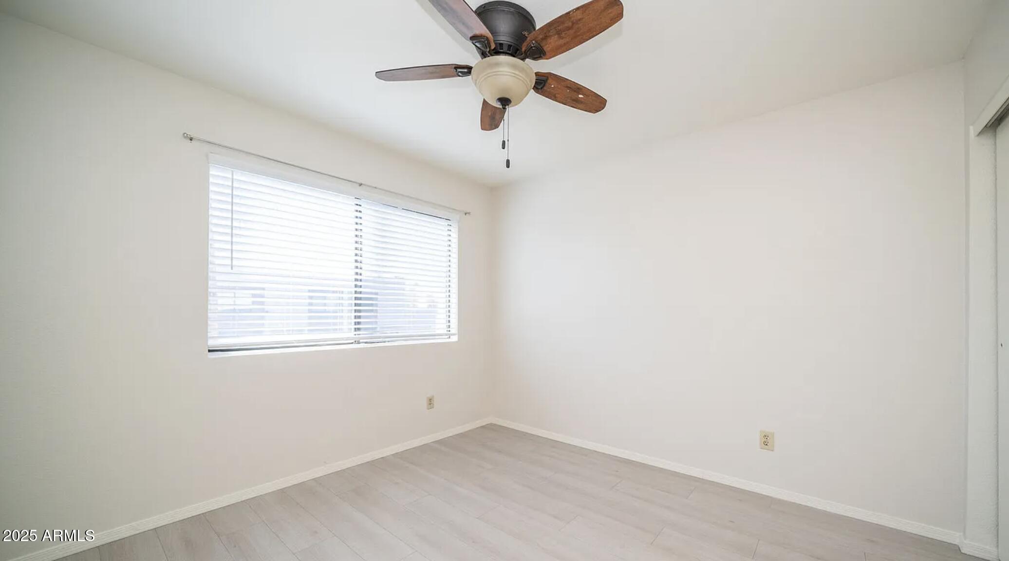 1329 South Mitchell Drive Tempe, AZ 85281 - Photo 13 of 21 an empty room with a window and a fan