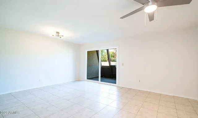 an empty room with a ceiling fan and a window