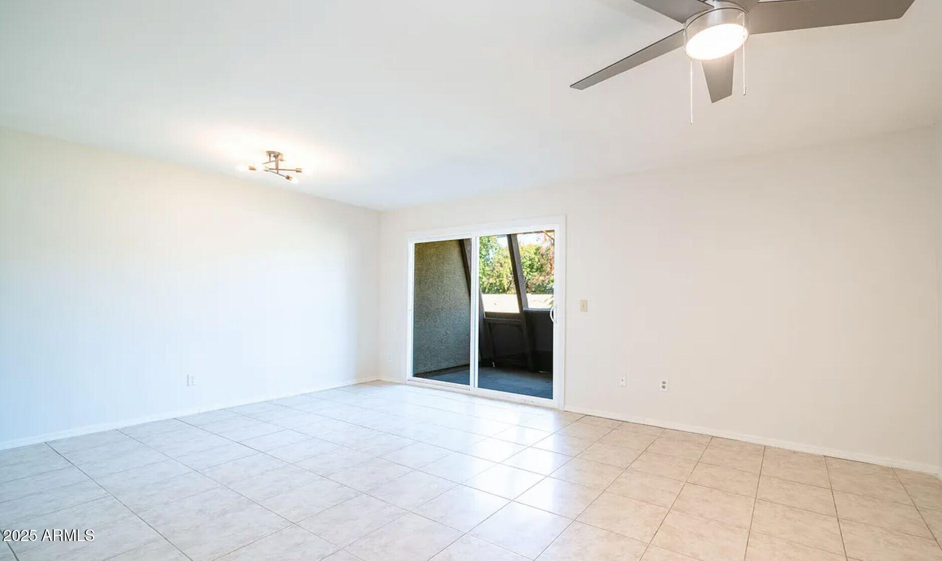 1329 South Mitchell Drive Tempe, AZ 85281 - Photo 3 of 21 an empty room with a ceiling fan and a window