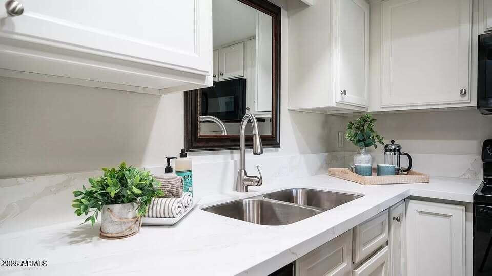 1329 South Mitchell Drive Tempe, AZ 85281 - Photo 6 of 21 a kitchen with a potted plant on the counter and cabinets