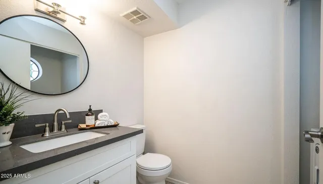 a bathroom with a toilet a sink and mirror