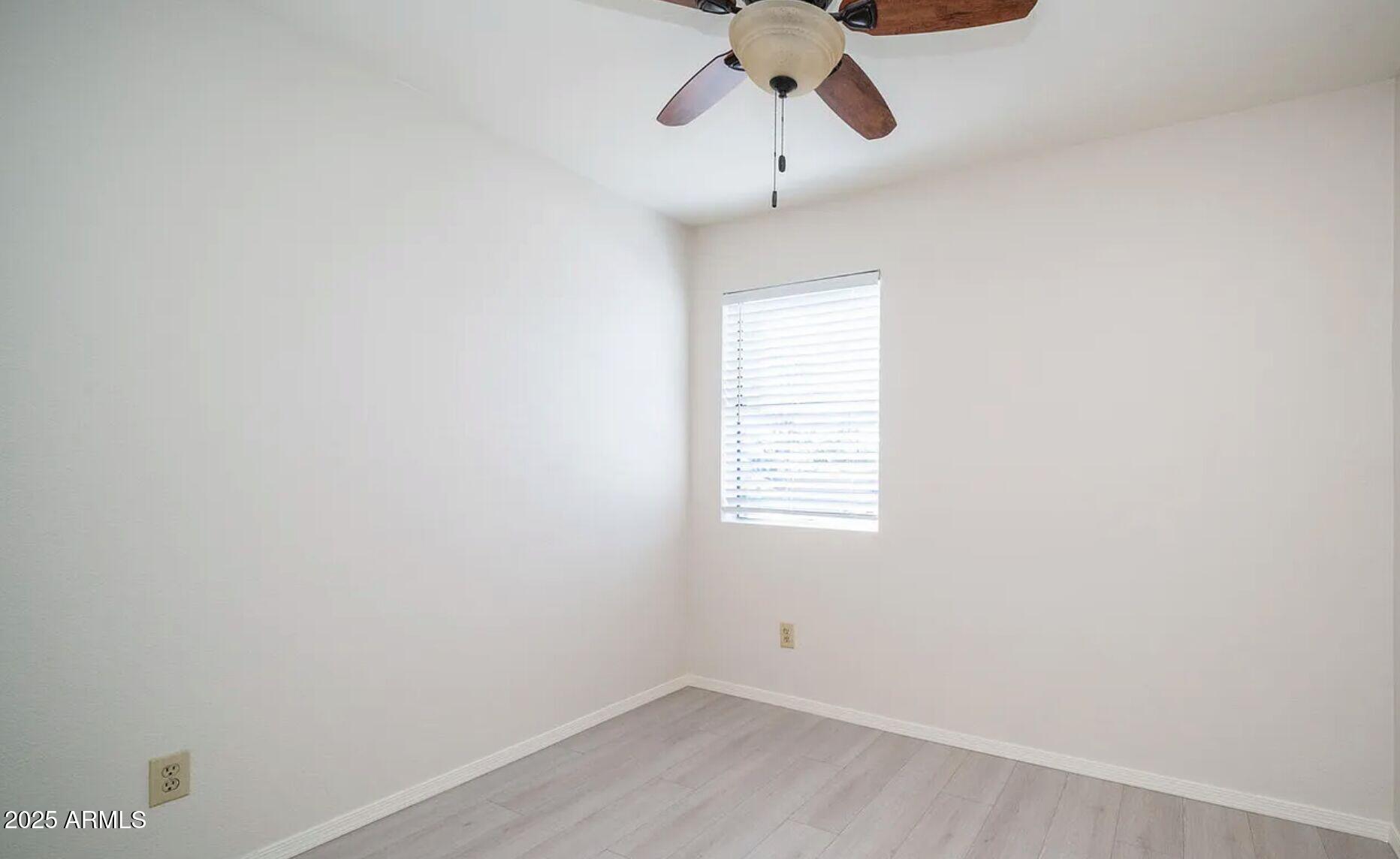 1329 South Mitchell Drive Tempe, AZ 85281 - Photo 10 of 21 an empty room with chandelier fan and windows