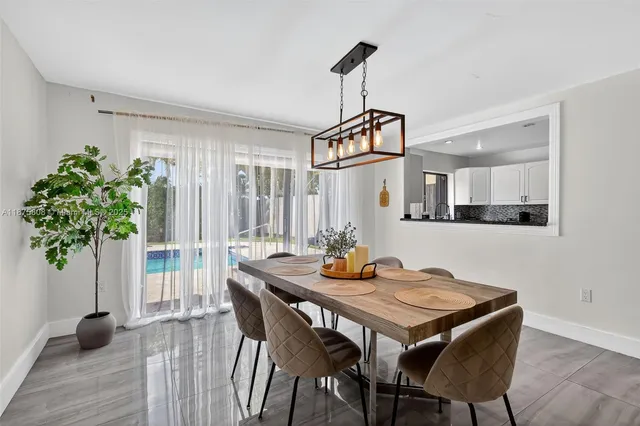 a kitchen with granite countertop a refrigerator a stove a sink and a wooden floor