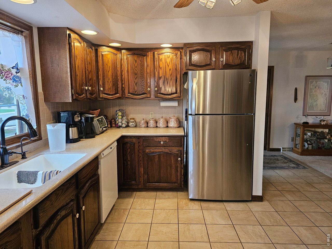 1010 Fairhurst Street Sterling, CO 80751 - Photo 14 of 36 a kitchen with a refrigerator sink and cabinets