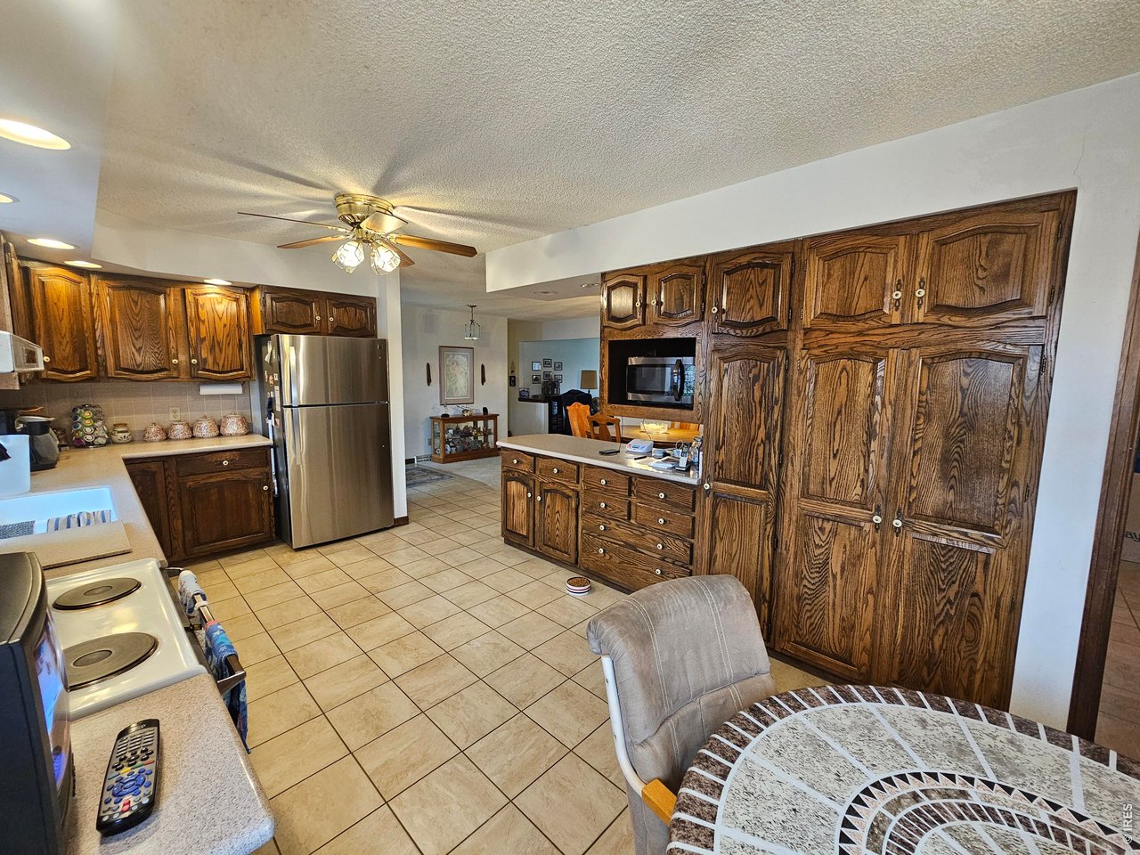1010 Fairhurst Street Sterling, CO 80751 - Photo 15 of 36 a kitchen with stainless steel appliances granite countertop a refrigerator a oven a sink a dining table and chairs with wooden floor