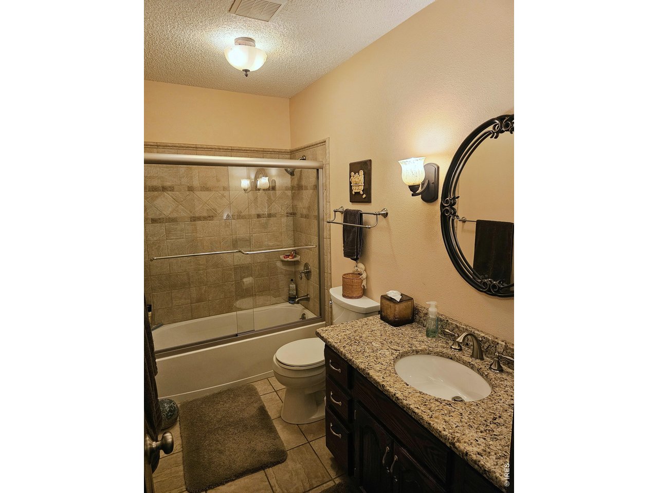 1010 Fairhurst Street Sterling, CO 80751 - Photo 17 of 36 a bathroom with a granite countertop sink mirror vanity and toilet