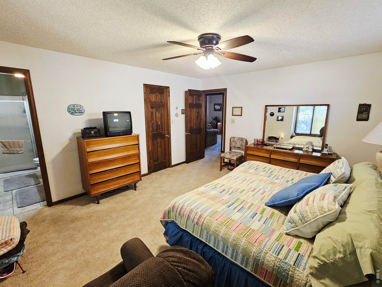 1010 Fairhurst Street Sterling, CO 80751 - Photo 25 of 36 a bedroom with a bed and a chandelier
